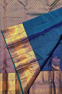 Blue and gold saree with intricate patterns on a textured fabric background