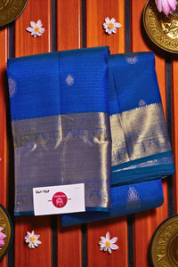 Blue and silver saree with a brand label on a wooden background