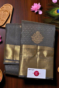 Two traditional sarees with gold and gray patterns on a wooden surface.