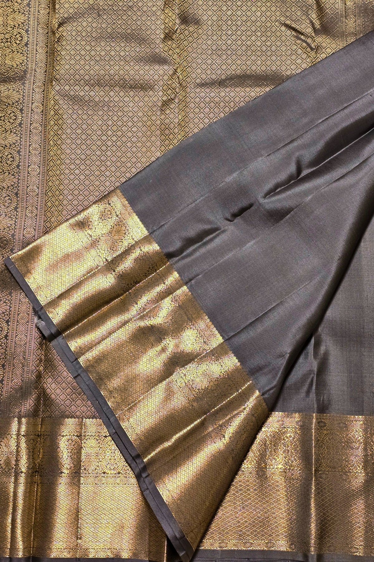 Close-up of a traditional fabric with gold and black patterns