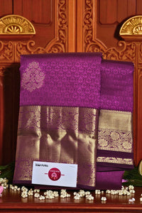 Purple and gold saree with a brand label on a wooden background