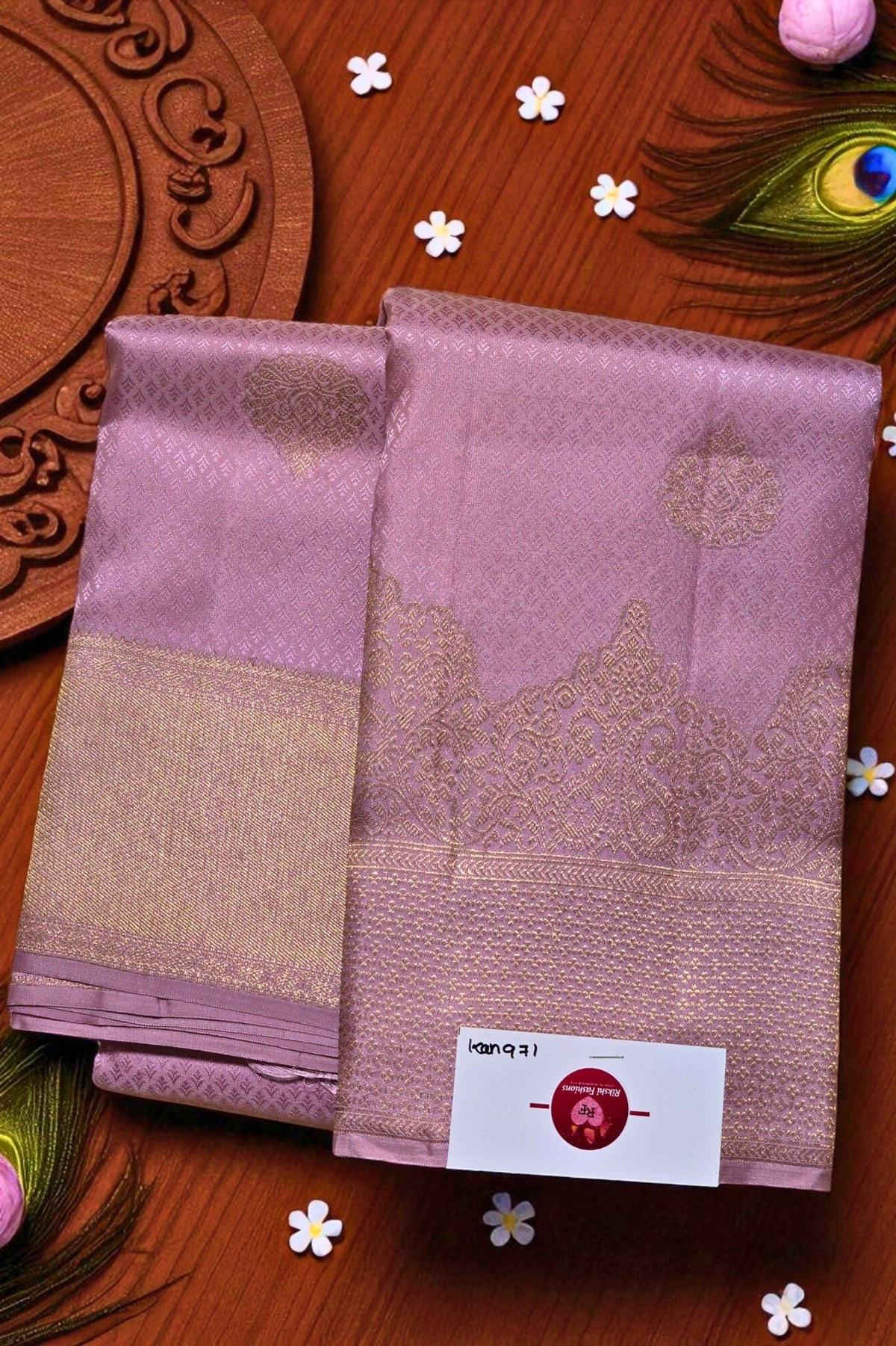 Two pink sarees with gold border on a wooden background