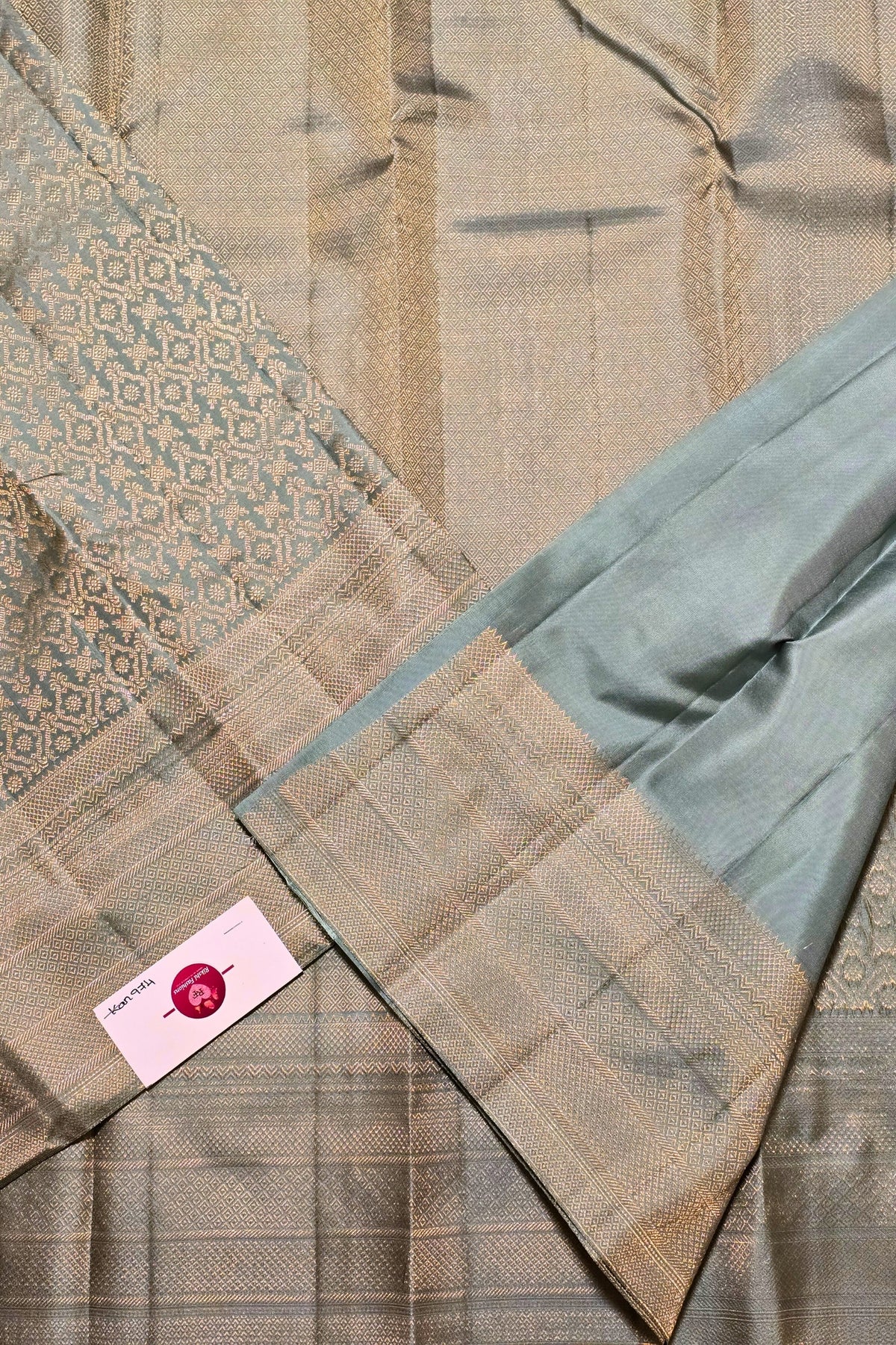Close-up of a quilt with geometric patterns and a brand label.