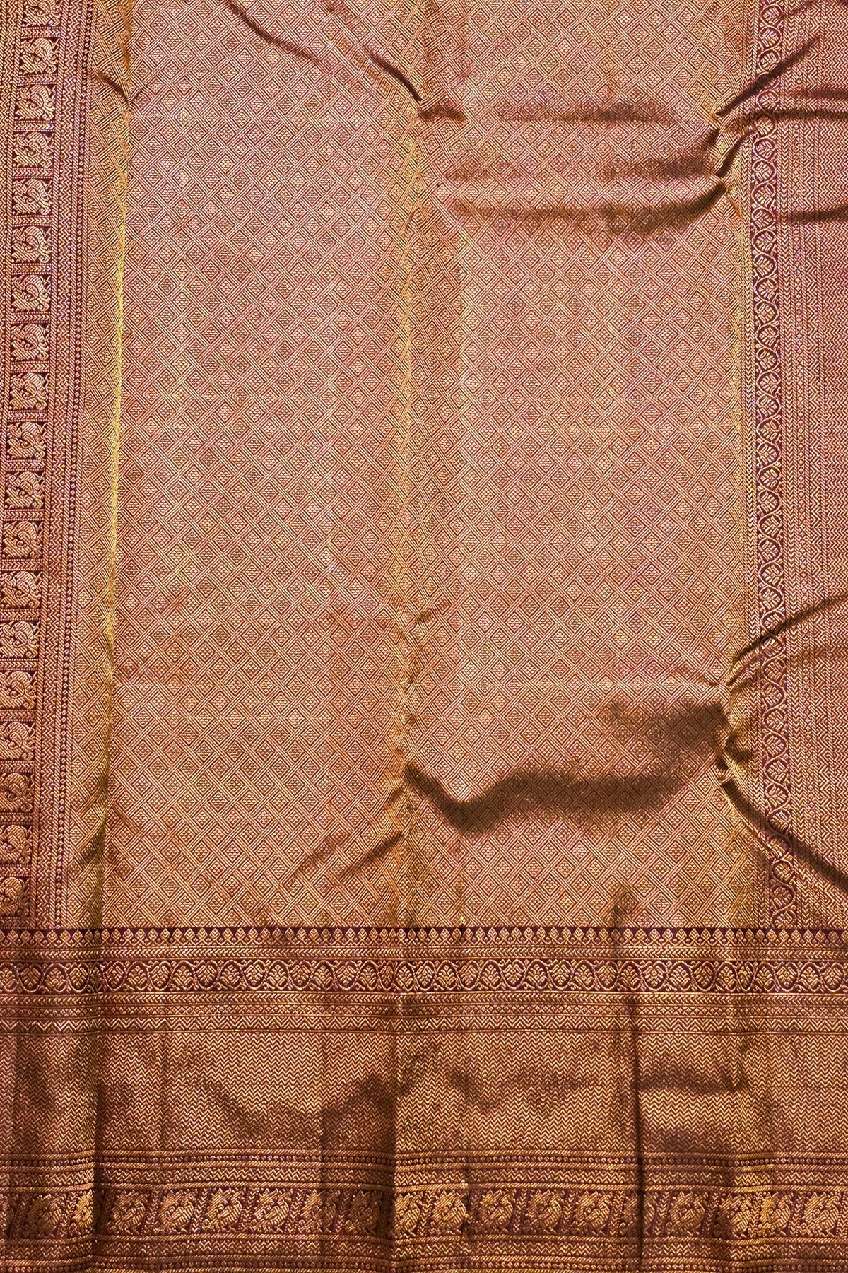 Close-up of a pink fabric with intricate patterns and embroidery