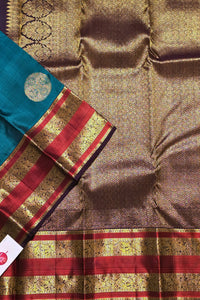 Traditional saree with a blue border and red and gold patterns on a brown background