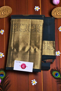 Black and gold saree with intricate patterns on a wooden background