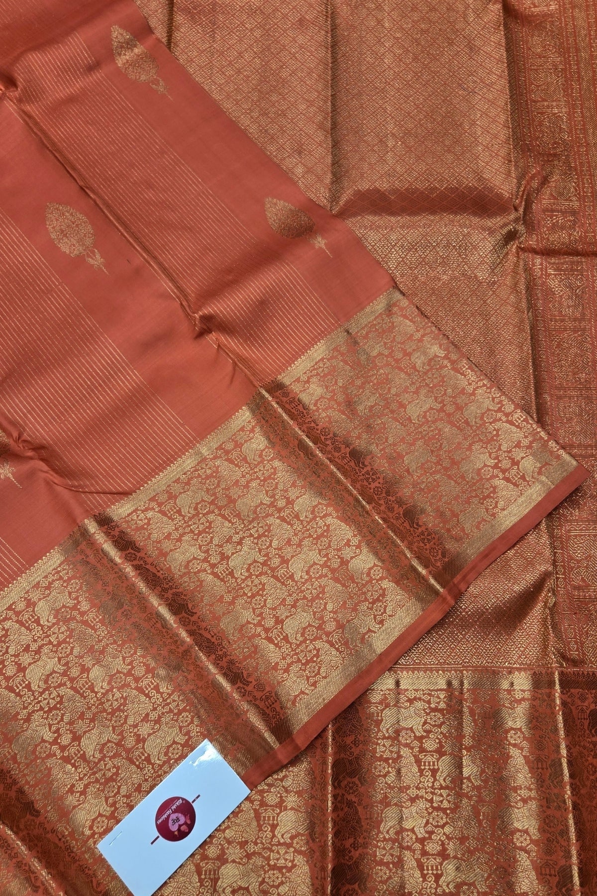 Brown saree with a patterned border on a matching fabric background