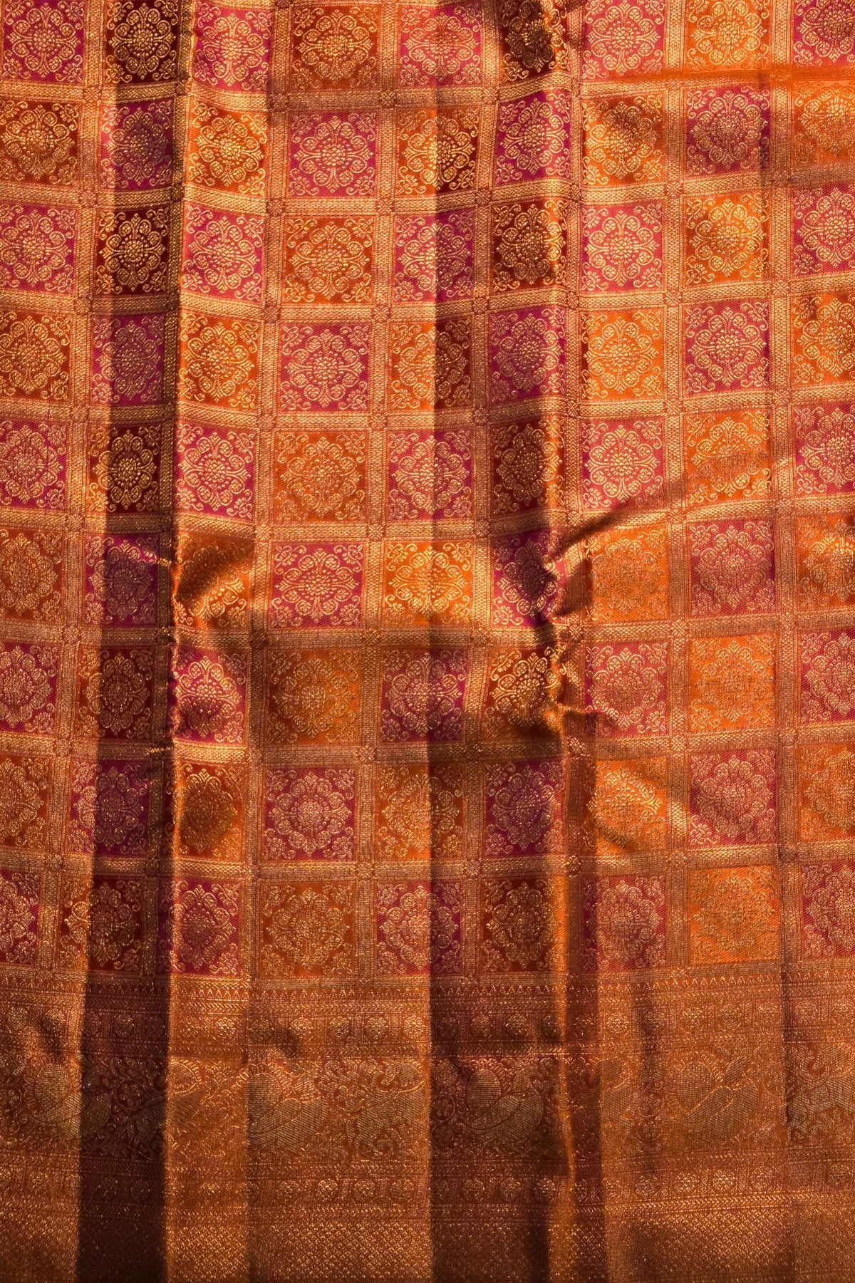 Patterned fabric with a checkered design in shades of brown, orange, and purple.