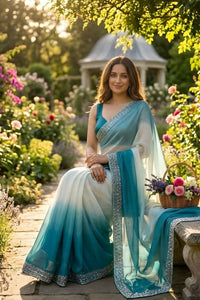 Woman in a blue and white saree sitting in a garden